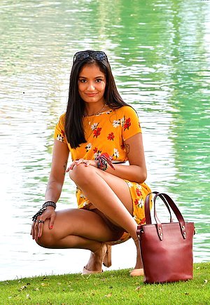 Brunette dressed in yellow strikes a few seductive poses outdoors