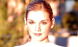 Ponytailed lady with a pretty face bends over to showcase her ass